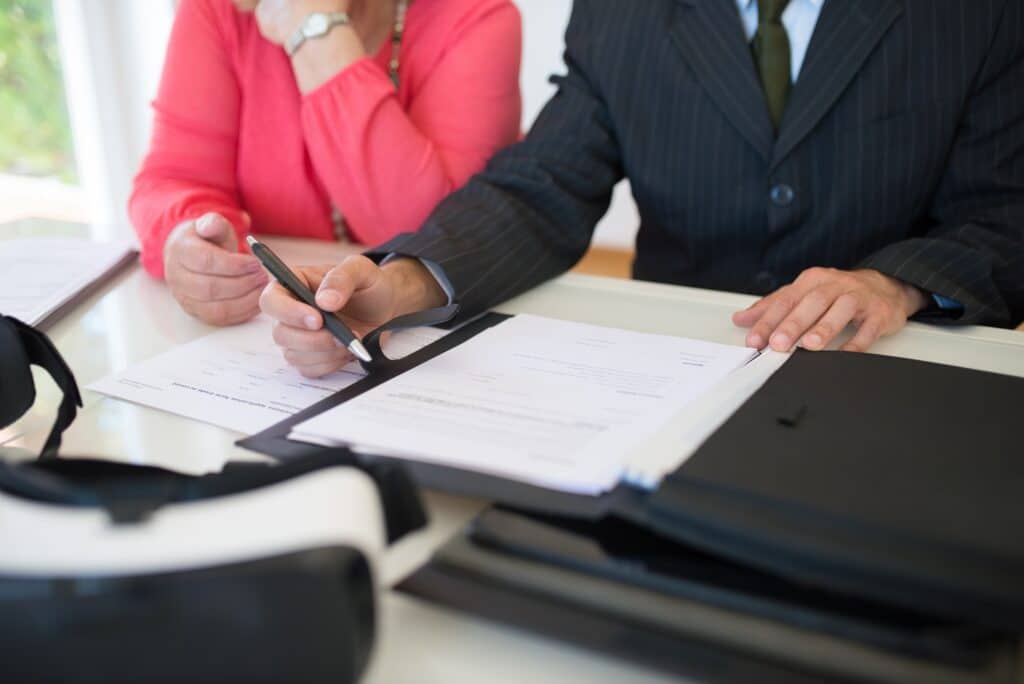 Two people signing a document representing what is required for a valid will