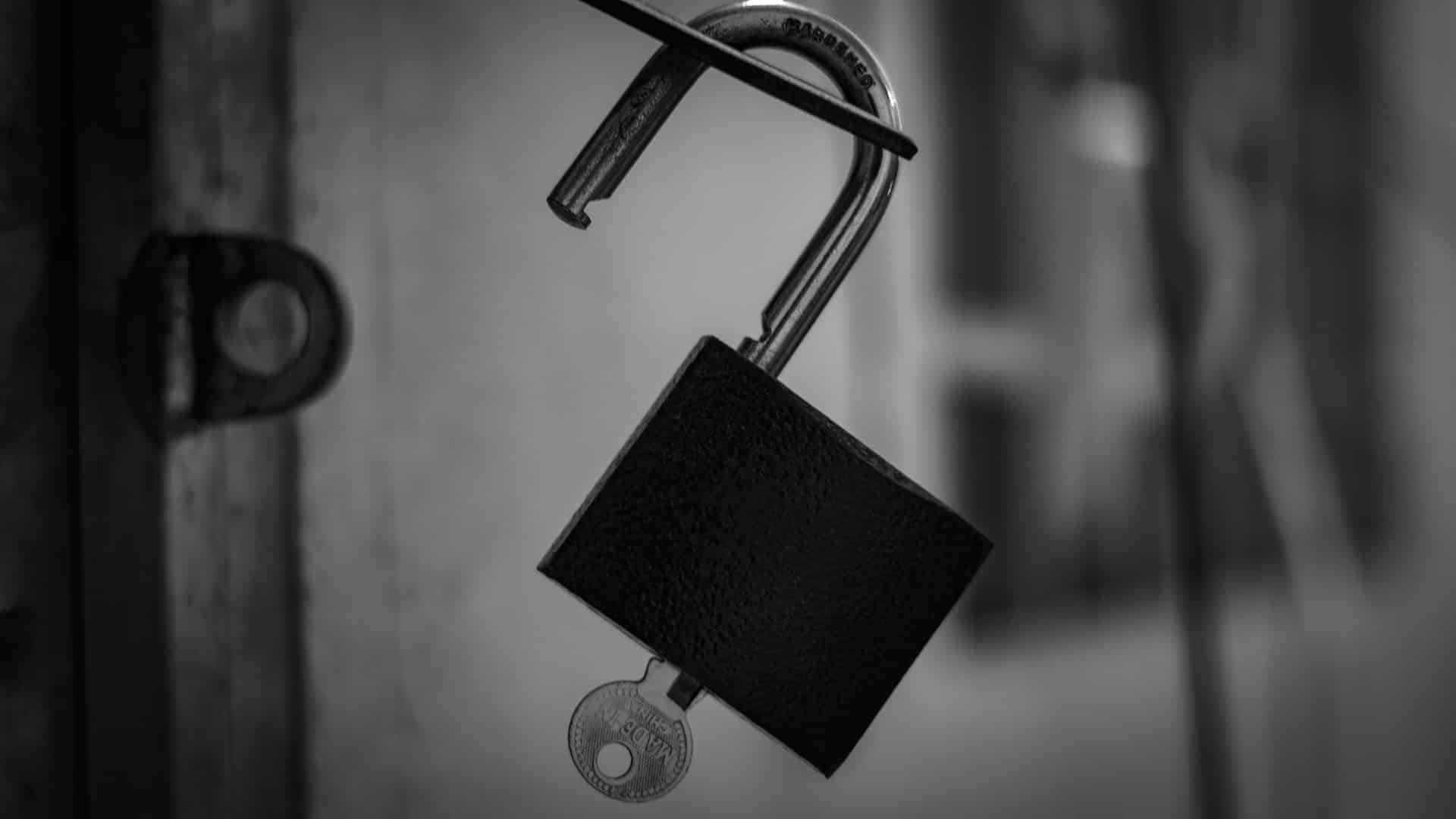 black and silver padlock in grayscale photo