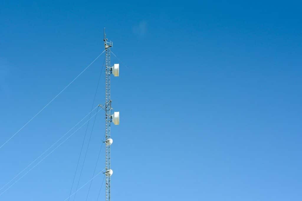 a tall cellphone tower with bluesky background