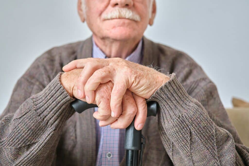a close-up of an elderly man with a cane