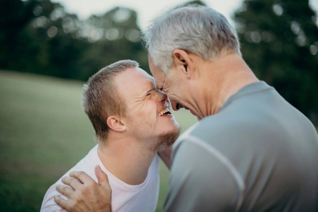 An older man hugging a man with a disability, representing Committeeship vs. Adult Guardianship BC