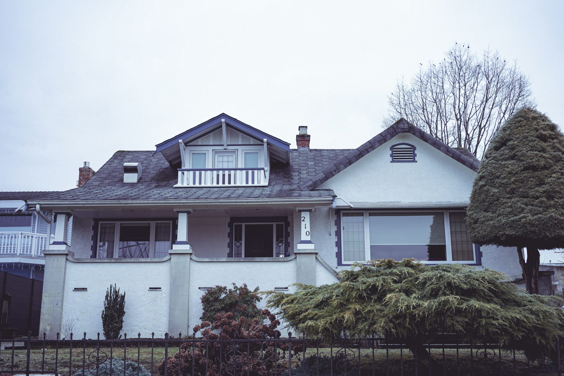 A stately home in Vancouver surrounded by a wrought iron fence and greenery, representing the property dispute lawyers at Meridian Law Group who advise clients across BC on partition of property matters, boundary issues, riparian rights, real estate agent negligence and fraud, commercial lease disputes, neighbour disputes, and easements and rights of way.