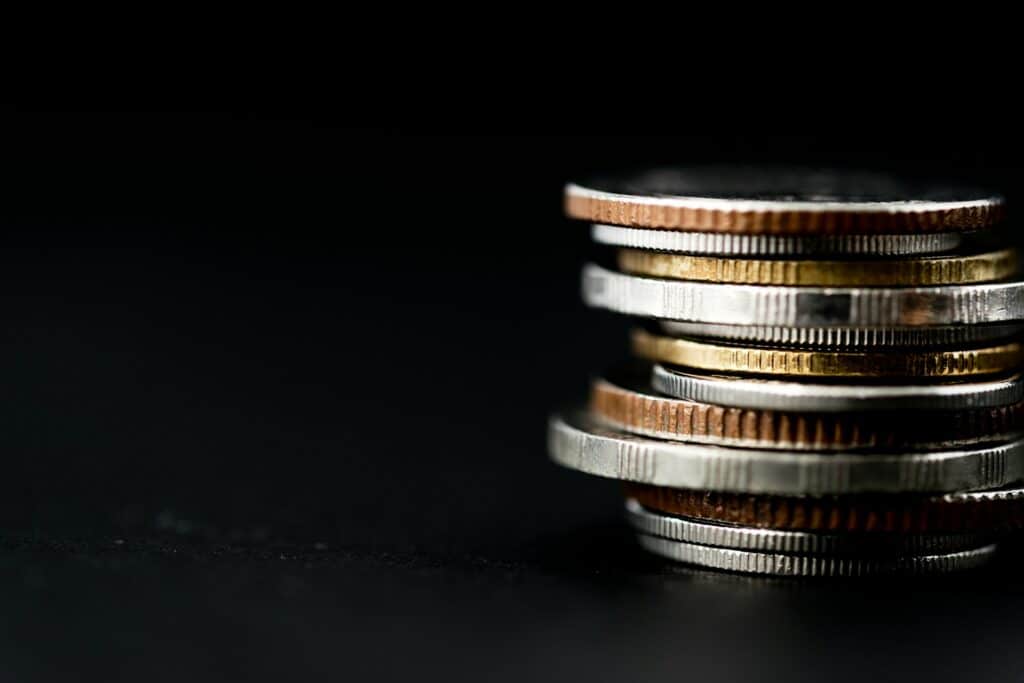 A stack of coins against a black background, representing child support disputes and income imputation