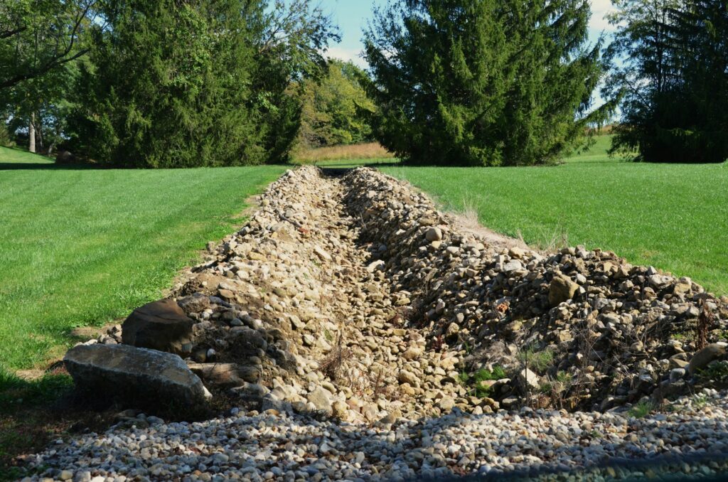 A trench dug into a grassy property, representing stormwater disputes in British Columbia
