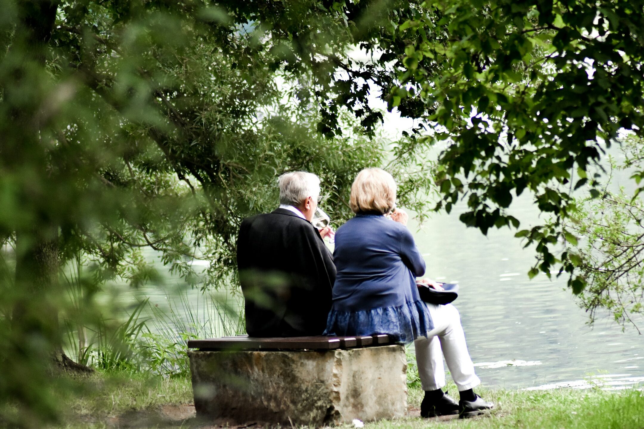 An older couple sitting together in a park staring at a pond, representing the power of attorney litigation lawyers at Meridian Law Group in Vancouver, and removing an attorney under BC estate and elder laws.
