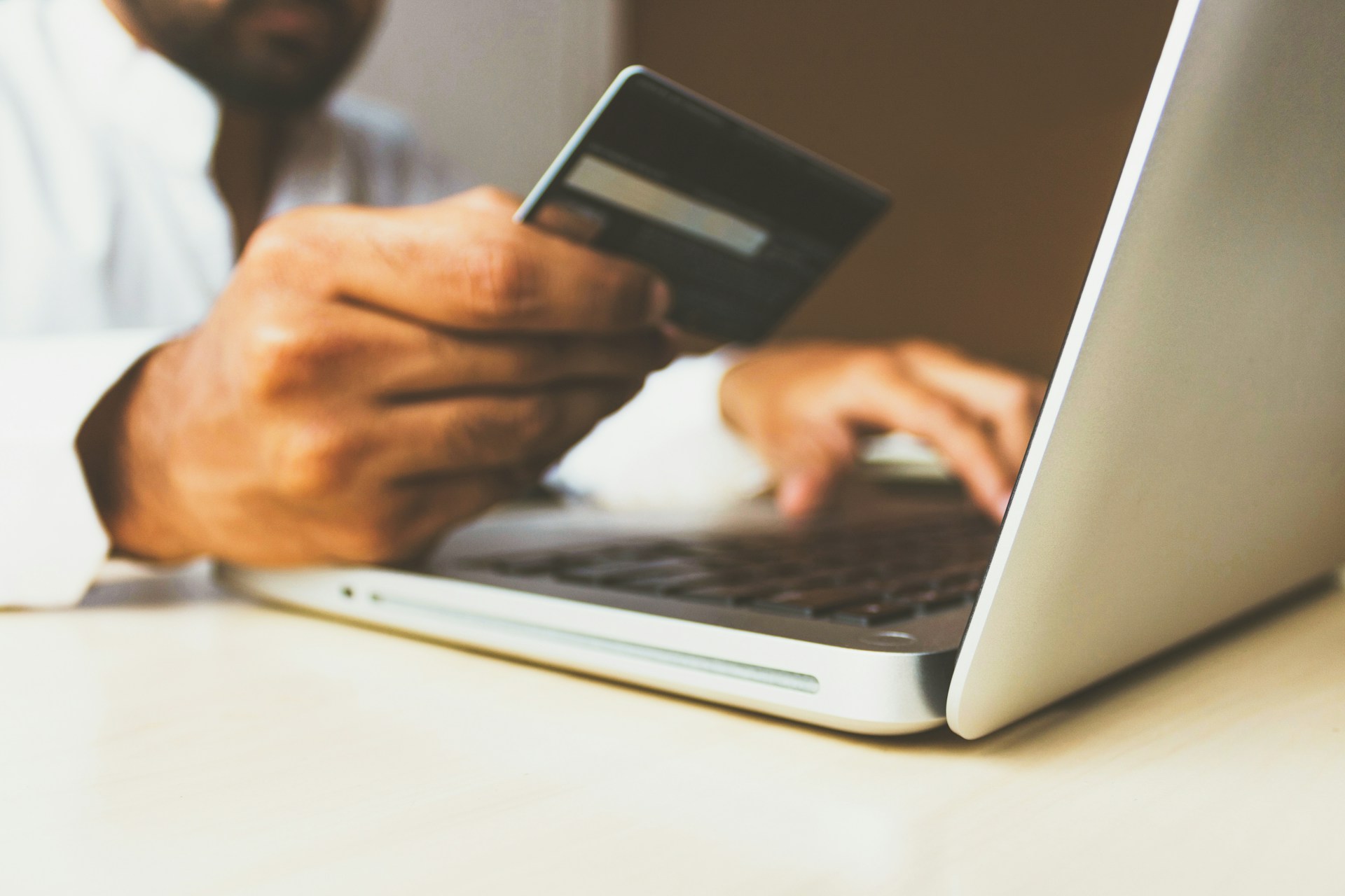 A person holding a credit card and looking at computer, representing Digital Assets and B.C. Family Law.
