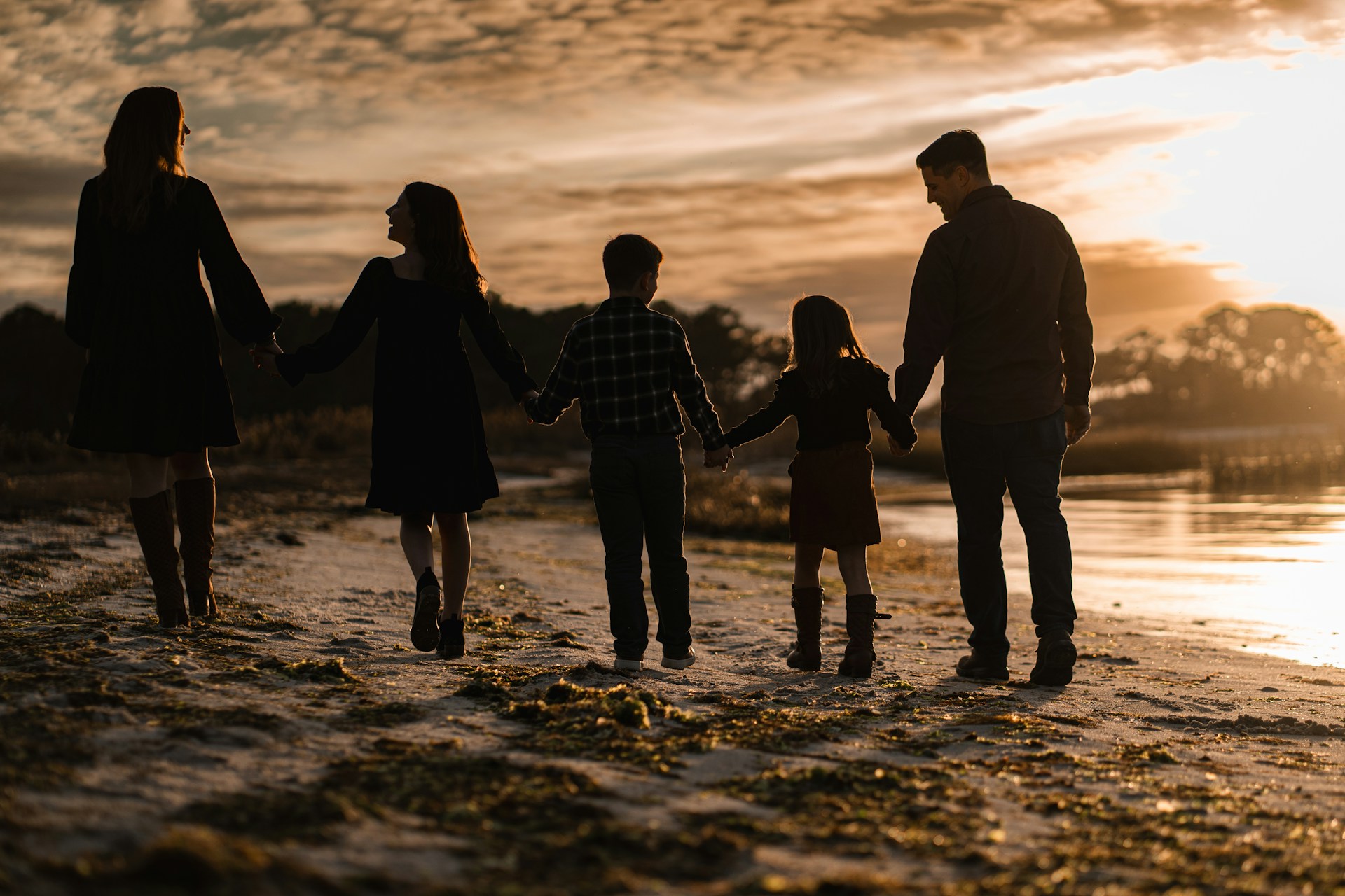 A family walking on a beach at sunset, representing blended families and child support in B.C.