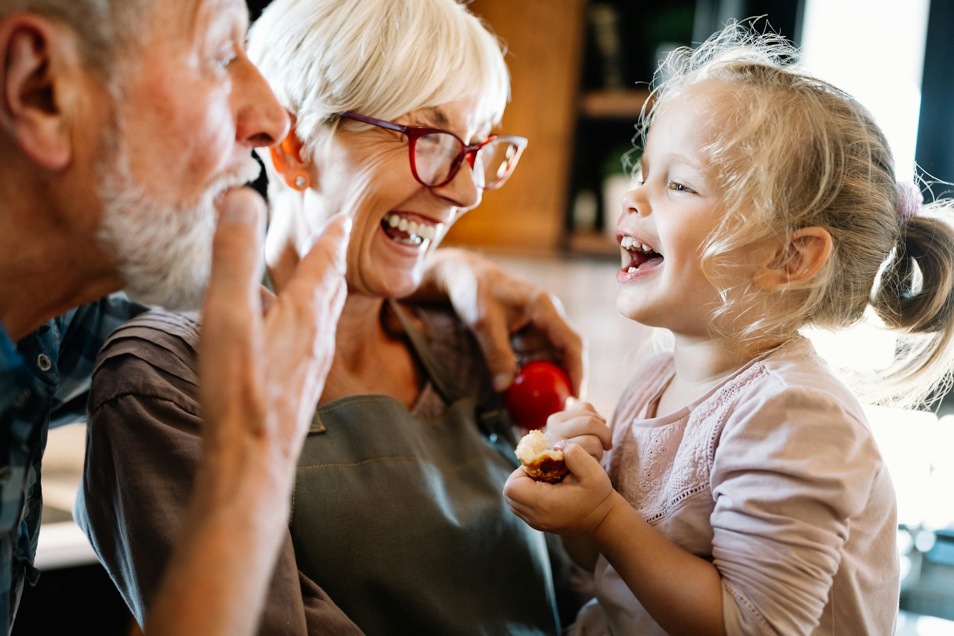 Grandparents playing with their granddaughter, representing grandparent contact rights after separation and divorce.